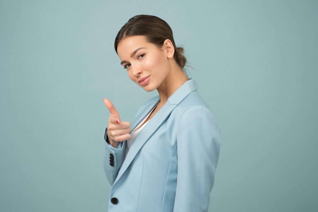 pexels-photo-1036622-1036622 A young woman in a blue suit exhibits confidence with a relaxed pose against a blue background.